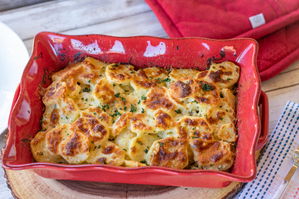 golden scalloped potatoes in a red casserole