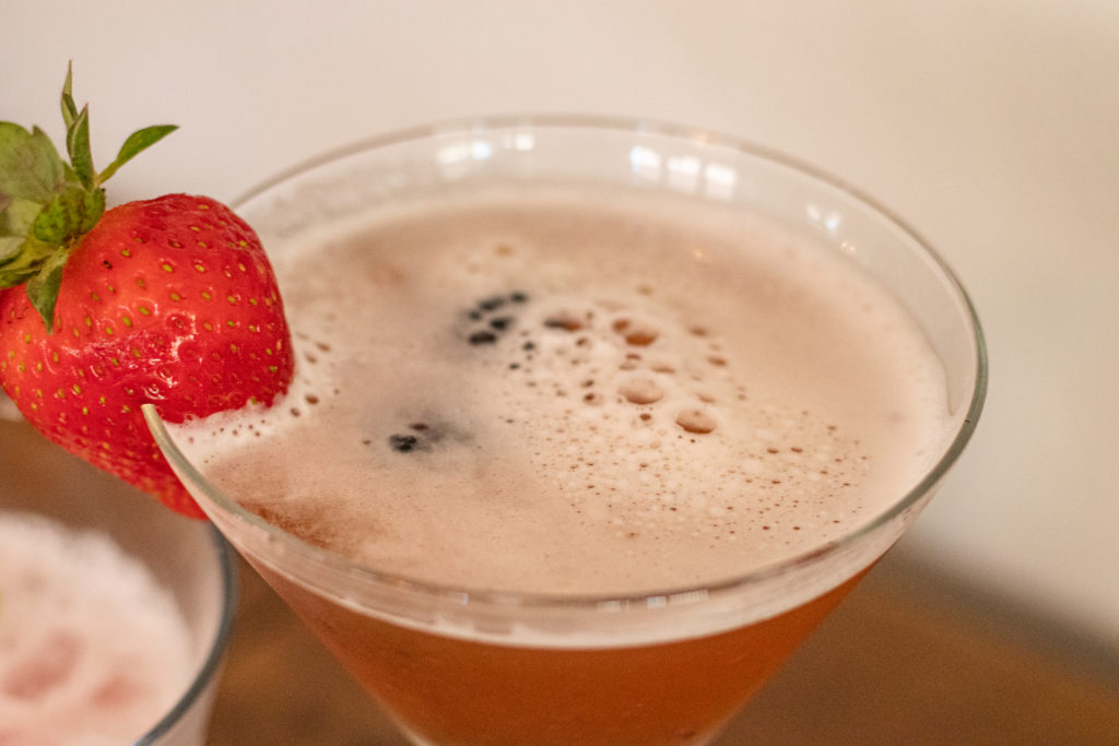 top of a martini glass with a strawberry as garnish. The martini is a Lunar Berry Martini.