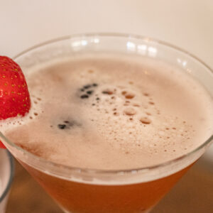 top of a martini glass with a strawberry as garnish. The martini is a Lunar Berry Martini.