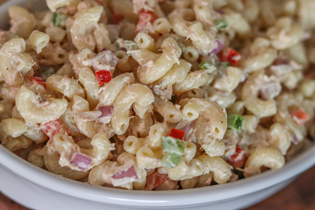 Ensalada de Coditos con atún (Tuna pasta salad) in a super close shot. You can see every single ingredient. From the pasta, mayo, red onions, red and green peppers.
