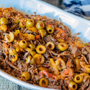 Instant Pot Ropa Vieja, a Cuban staple. Beef with Latin seasonings, peppers, olives and onions. Its on a platter, ready for serving.