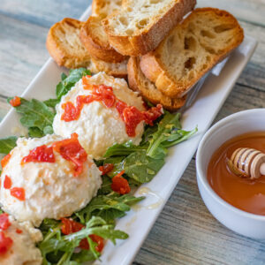 Sweet and Spicy Whipped Feta. Sweet, salty and velvety rich, this Whipped Feta is the perfect appetizer. Served with toasted ciabatta, arugula, and drizzled with honey.