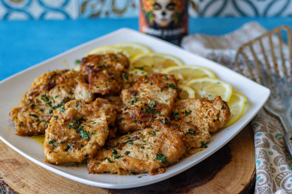 Lemon Carne Asada Pork Chops on a plate over lemon wedges. 8 pieces that are thin and boneless.
